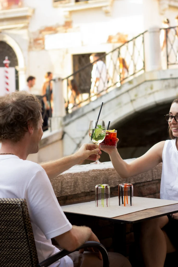 Coppia brinda con cocktail all'aperto vicino a un canale di Venezia, Cantinone Storico