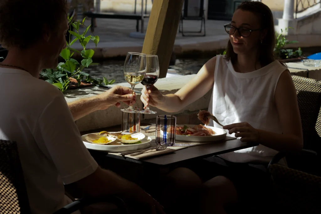 Coppia di clienti brinda con vino a un tavolo del ristorante, galleria fotografica Cantinone Storico Venezia
