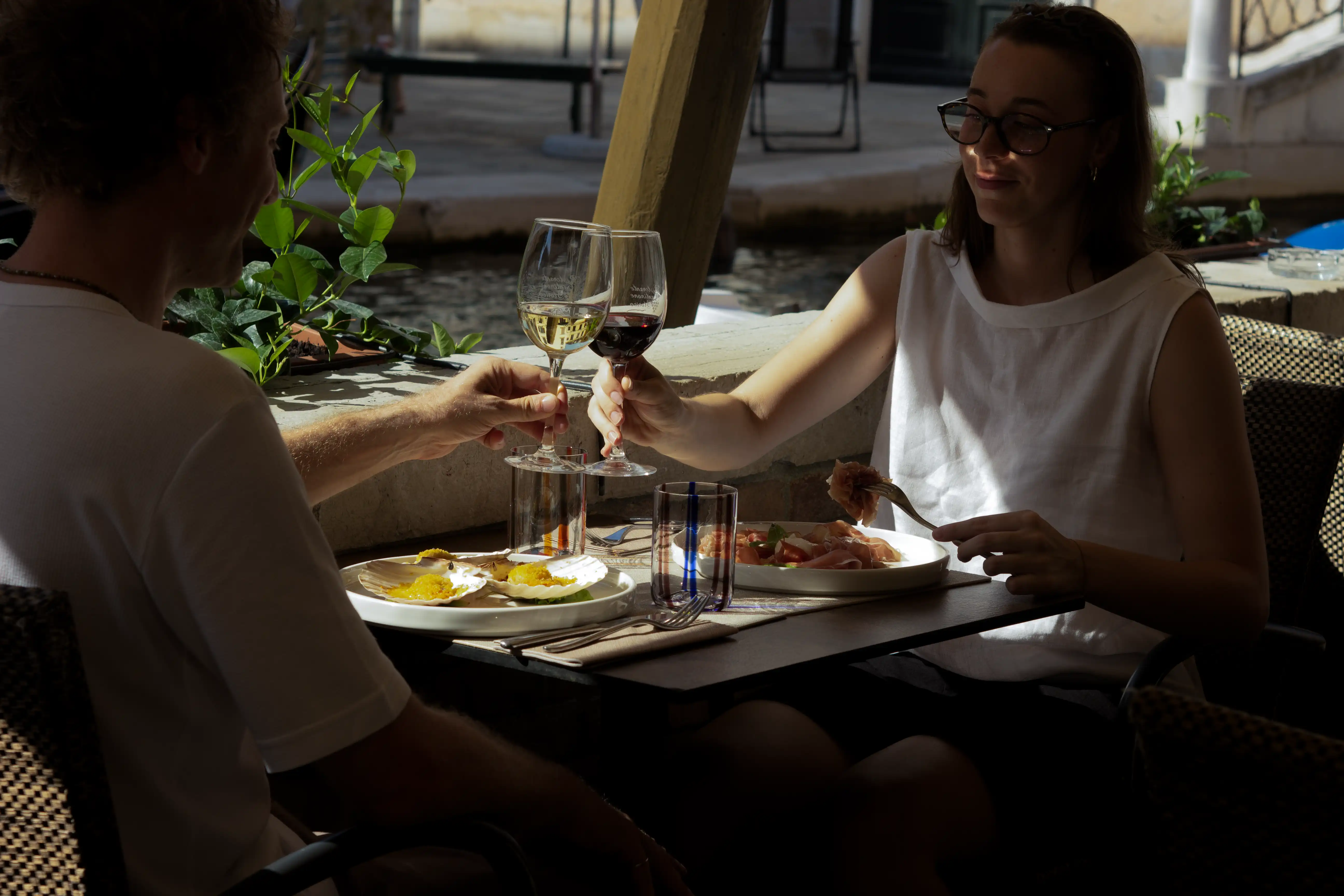 Coppia di clienti brinda con vino a un tavolo del ristorante, galleria fotografica Cantinone Storico Venezia